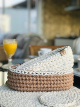 Círculo Barroco Maxcolor Sparkle – Cotton Yarn (216m / 200g) - A crocheted pet bed with a two-tone design, featuring a cream-colored top half and a natural beige-brown bottom half, styled on a matching textured rug in a cozy, blurred indoor setting.