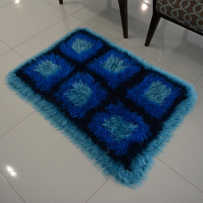 Circulo Natural Luxury Decor - Fluffy  Effect Yarn, 180 m / 280 g - Blue textured rug on a white tiled floor